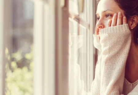 Femme regardant par la fenetre