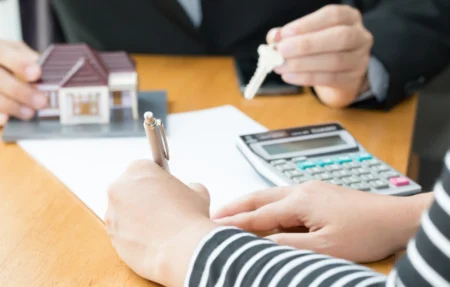 Personnes avec calculatrice et maison