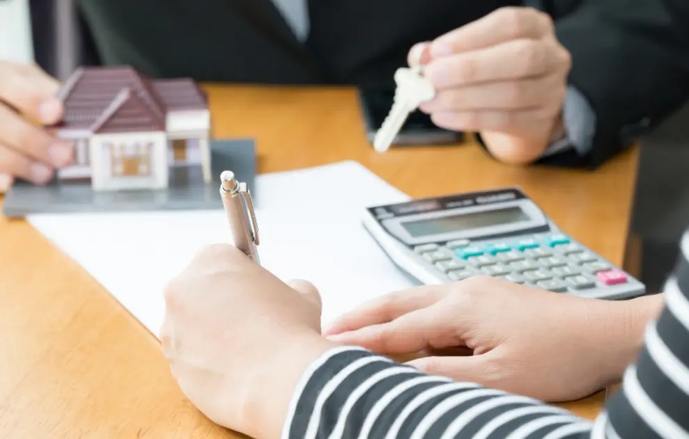 Personnes avec calculatrice et maison