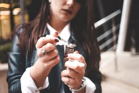 Femme qui met du e-liquide au CBD dans sa vapoteuse